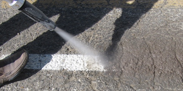 Removing parking lot lines with wet abrasive blasting