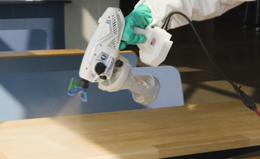 Spraying wooden surface with List-N disinfectant