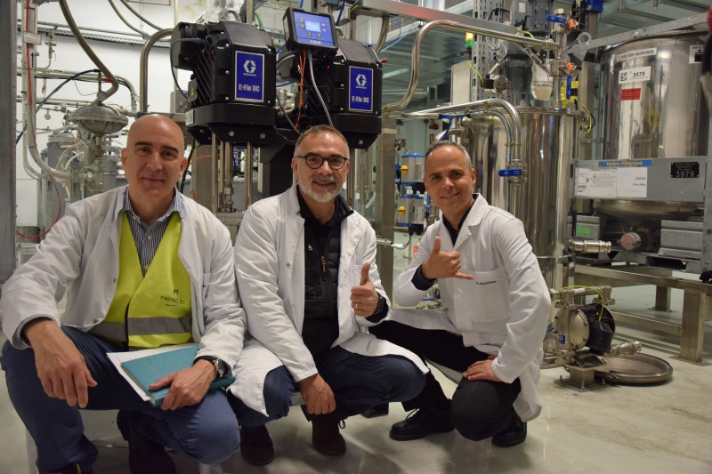 Seat employees smiling in front of the Graco update to their paint shop