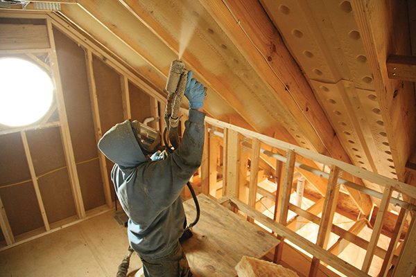 mand sprøjter skum på et loft