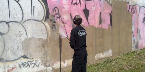 Blasting graffiti off a concrete wall