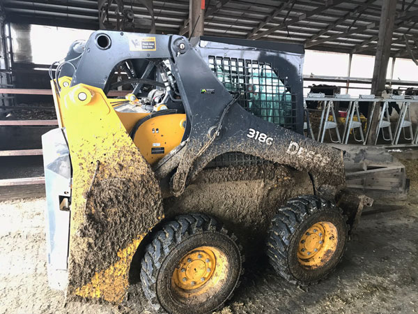 G-Mini auto lube pump on skid steer in cattle barn