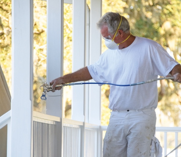 Contractor using an airless paint sprayer