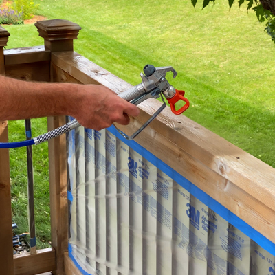 Photo d'une personne en train de peindre des balustrades avec un pulvérisateur airless